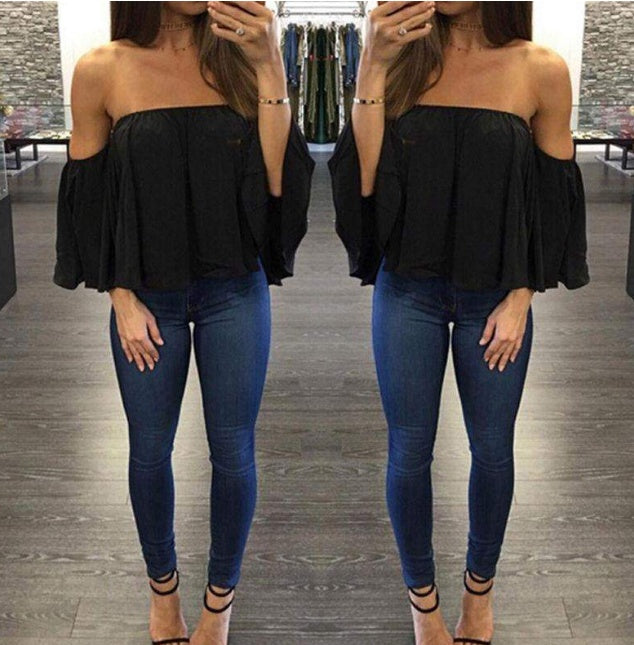 Woman wearing a black off-shoulder top and blue jeans in a fitting room.