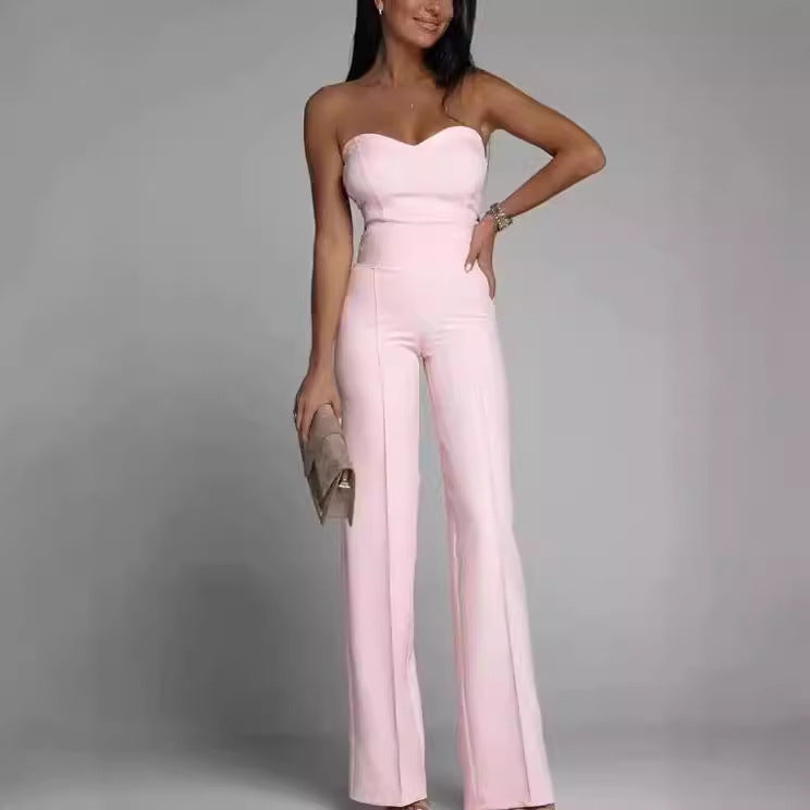 Woman wearing a strapless pink jumpsuit against a gray background