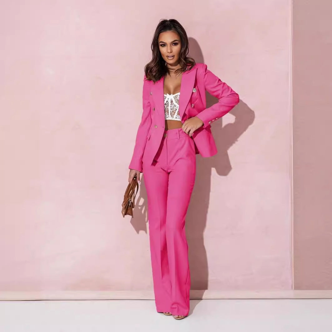 Woman in a pink suit standing against a pink background