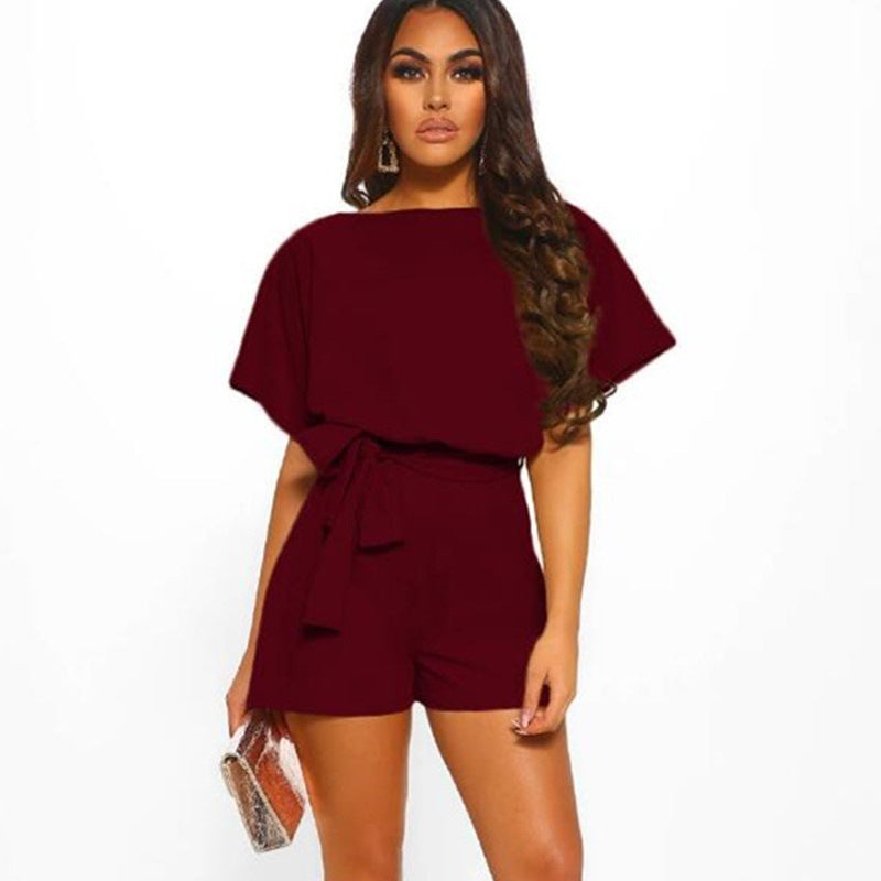 Woman wearing a burgundy romper on a white background