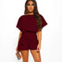 Woman wearing a burgundy romper on a white background