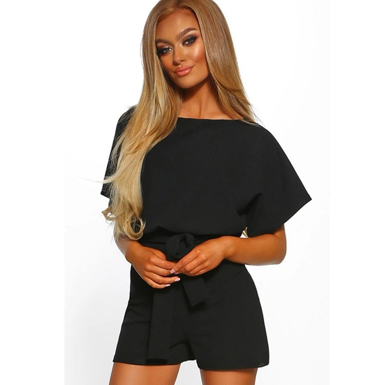 Woman wearing a black romper on a white background