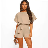 Woman wearing a beige romper on a white background