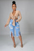 Woman wearing a beige cardigan and light blue ripped jeans on a gray background
