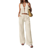 Woman wearing a beige jumpsuit holding a straw bag on a white background