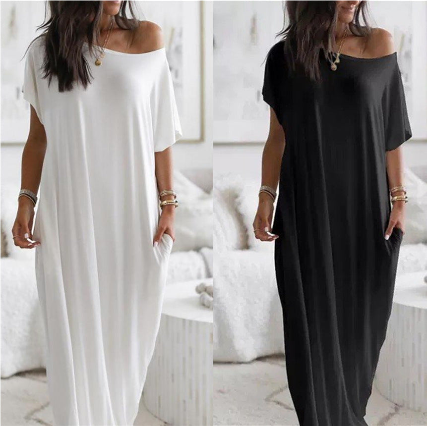 Two women wearing off-shoulder maxi dresses, one white and one black, in a bright room.