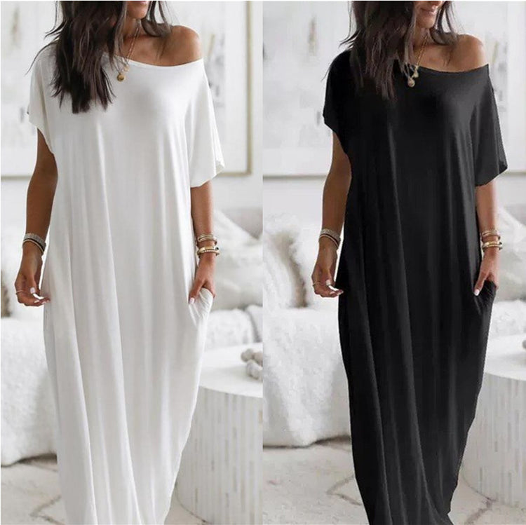 Two women wearing off-shoulder maxi dresses, one white and one black, in a bright room.