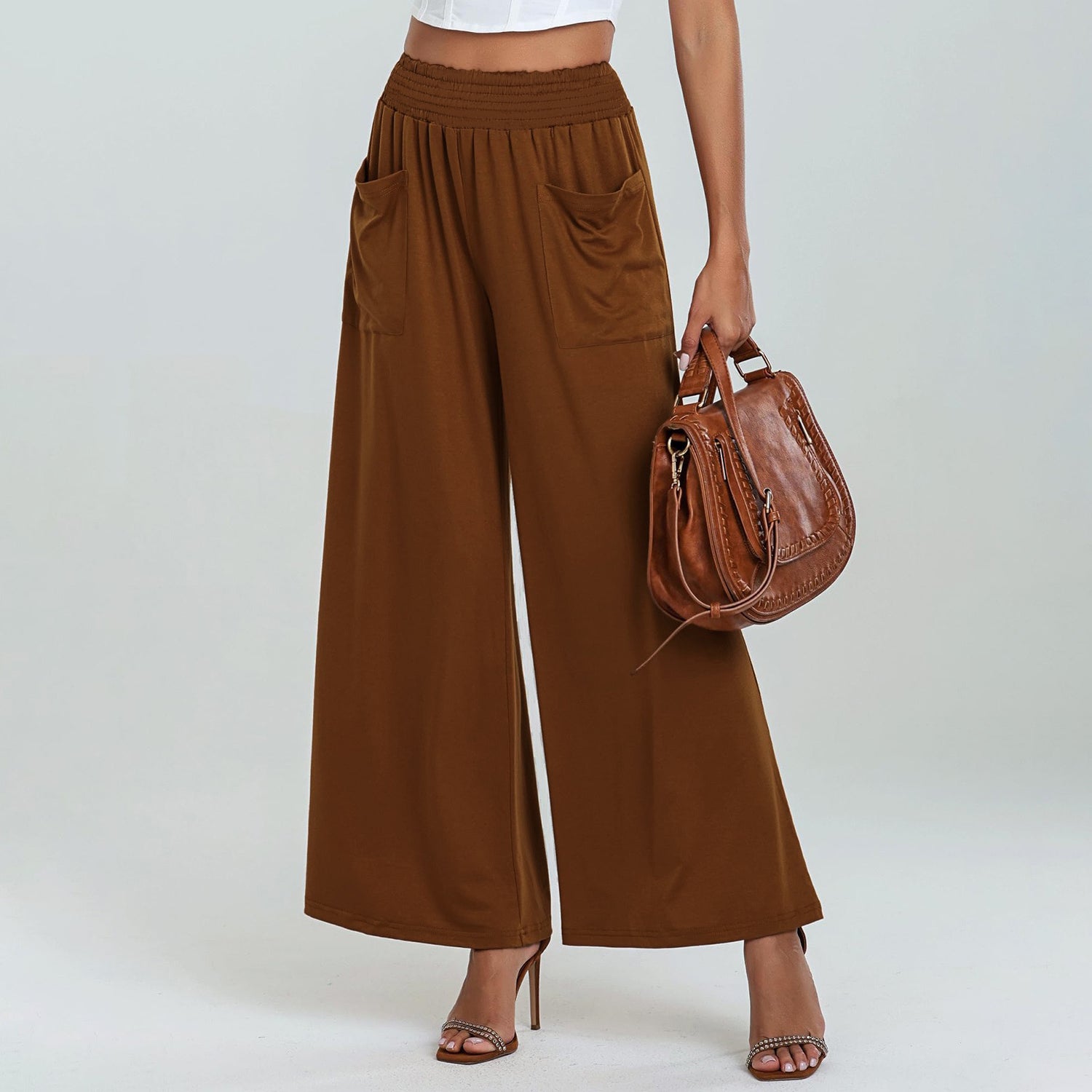 Brown wide-leg pants with a matching handbag on a plain background