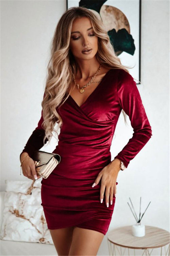 Woman wearing a red dress with long sleeves in an indoor setting.