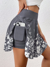 Gray floral skirt with a pocket holding a phone against a white background