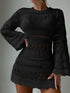 Black crochet dress worn by a person on a plain background