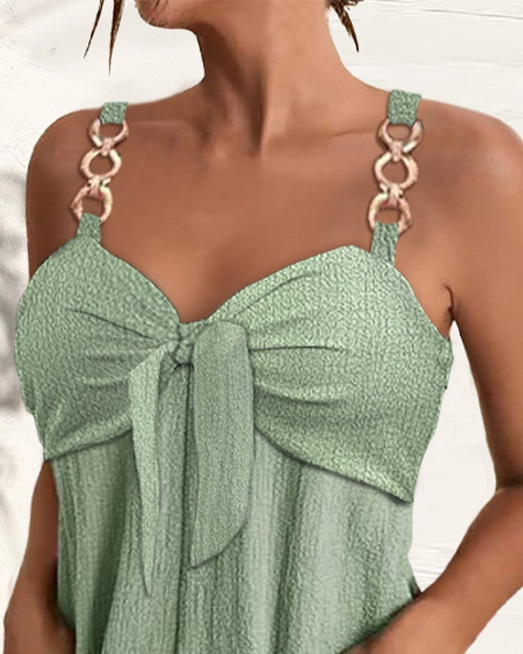 Green dress with chain straps worn by a model on a white background