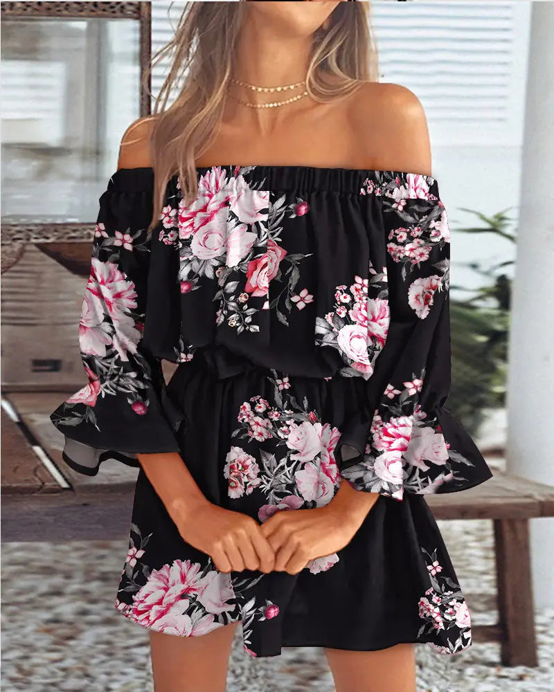 Black off-shoulder dress with pink floral pattern worn by a person.
