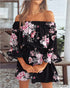 Black off-shoulder dress with pink floral pattern worn by a person.