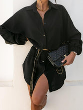 Person wearing a black outfit with a quilted handbag against a white background