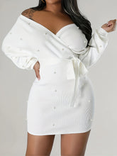 White off-shoulder dress with pearl embellishments on a gray background