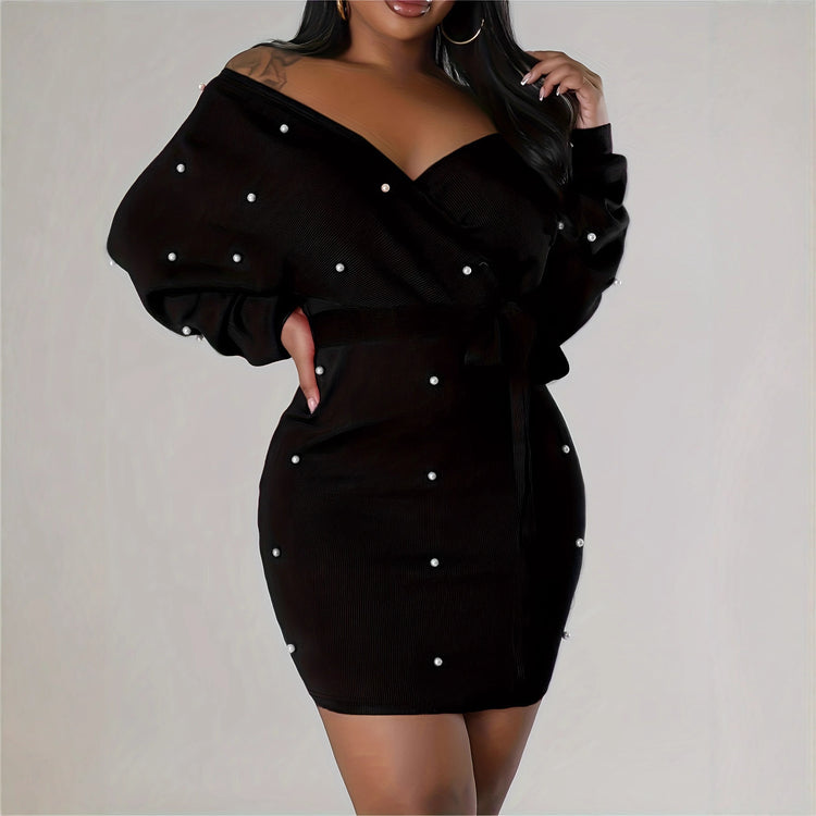 Black off-shoulder dress with pearl embellishments on a plain background