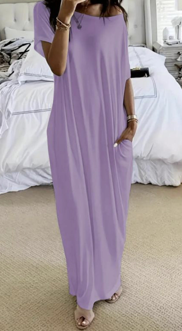 Person wearing a long purple dress in a bedroom setting