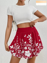 Person wearing a white crop top and red floral skirt on a light gray background