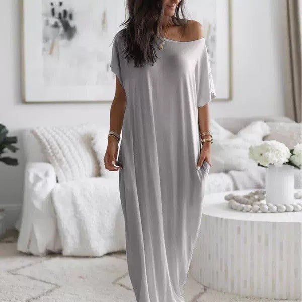 Woman wearing a gray off-shoulder dress in a stylish living room.